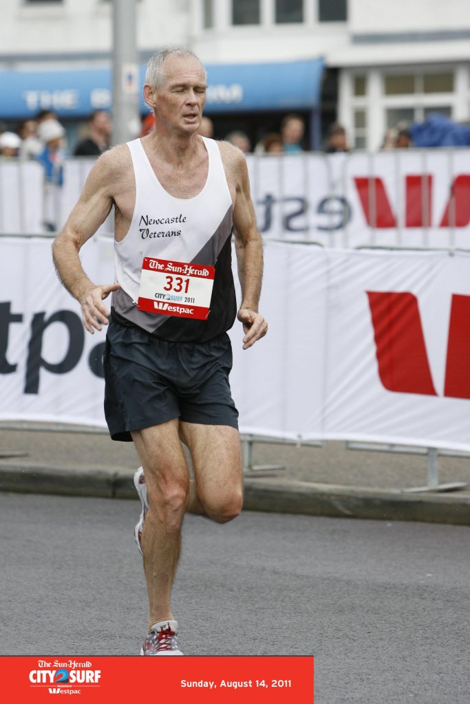 A man in athletic gear sprinting along a marathon route, showcasing determination and endurance.